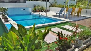 a pool with a table and chairs and plants at PD ROOM STAY in Port Dickson