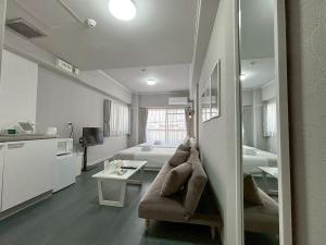 una sala de estar con un sofá y una cama en Neighbor's Hotel 西十日市, en Hiroshima