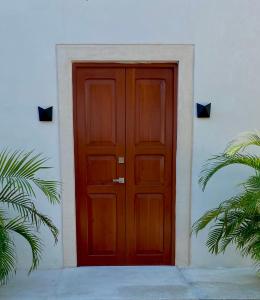 una puerta roja en el lateral de un edificio blanco en Casa Palma, en Campeche