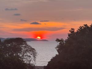a sunset over the ocean with the sun in the sky at Hostel Friends Station & Cafe in Pattaya South