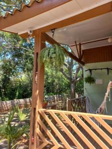 a porch with a hammock and a tree at Cabana Caminho de Pedras in Montenegro
