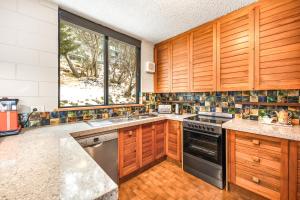 een keuken met houten kasten en een groot raam bij Pontresina 1 in Falls Creek +11 foto's