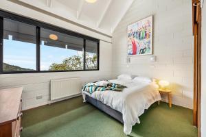 een slaapkamer met een bed en een groot raam bij Pontresina 1 in Falls Creek