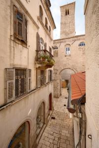 an alley in an old building with a clock tower at Palazo dei CONTI in Split Centre OLD town in Split