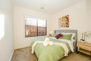 a bedroom with a bed and a window at New family-friendly home in Melton South +21 photos