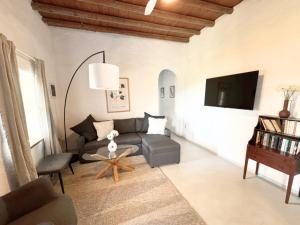 a living room with a couch and a tv at Kotseli - Sea View, Pool, Sunsets in Andros