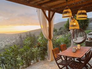 a table and chairs on a porch with a view at Kotseli - Sea View, Pool, Sunsets in Andros