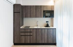 a kitchen with wooden cabinets and a sink at Apartamentos Ca Gracia 2 adaptado in Bocairent