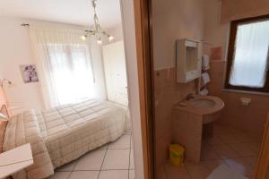 a bedroom with a bed and a bathroom with a sink at Haidi House in Agerola +79 photos