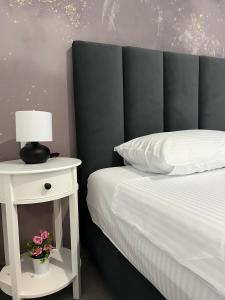 a bed with a white nightstand next to a bed with a lamp at Blue Breeze Apart-Danai B in Ofrínion +19 photos