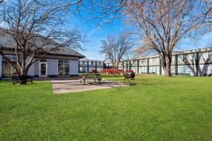 a park with two picnic tables in front of a building at Quality Inn Fort Dodge in Fort Dodge