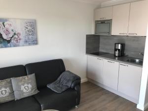 a living room with a couch and a kitchen at Sylter Rose in Süderende