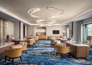 a waiting room with chairs and tables and a chandelier at Atlantis, The Palm in Dubai
