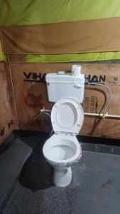 a white toilet sitting next to a box at Camp Meraki in Sari