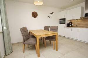 einen Esstisch und Stühle in der Küche in der Unterkunft Rex Rugia FeWo12-2 strandnah,Terrasse,Sauna,Pool in Lobbe