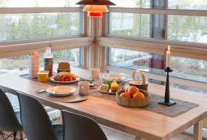 un tavolo con del cibo e una candela in una stanza con finestre di Sørbølhytta by Norgesbooking - cabin in Flå, close to Bjørneparken a Flå