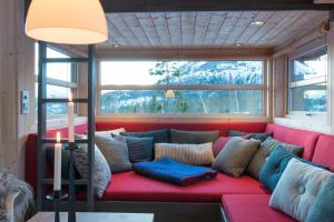 un divano rosso in una stanza con finestra di Sørbølhytta by Norgesbooking - cabin in Flå, close to Bjørneparken a Flå