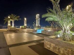a courtyard with palm trees and lights at night at Torre De Manila in Manila