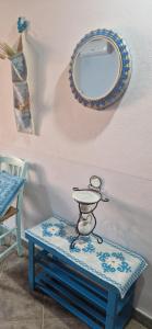 a mirror on a wall with a blue table with a mirror at Casa Susanna Rural Sardinia in Sini