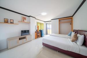a bedroom with a bed and a flat screen tv at One Residence Navanakorn in Pathum Thani