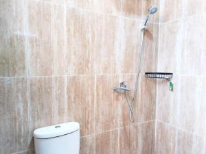 a bathroom with a shower with a toilet in it at Roemah Kavaleri powered by Cocotel in Bandung +24 photos