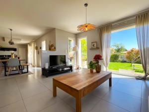 a living room with a table and a tv at Le temps de vivre in Mormoiron