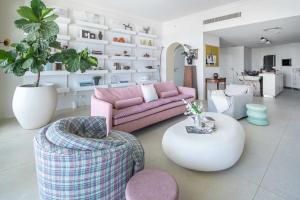 a living room with a pink couch and chairs at Frank Porter - Al Haseer in Dubai
