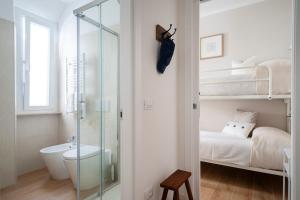 a bathroom with a shower and a bedroom with bunk beds at Charming staying by the sea in Rosignano Solvay +25 photos