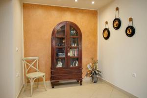 a living room with a wooden cabinet and a chair at Blue Oliva House in Aghia Marina
