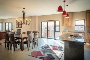Una cocina y un comedor con mesa y sillas. en 910 Highland Gate Golf & Trout Estate, en Dullstroom