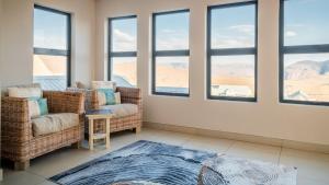 Una habitación con dos sillas y una mesa y ventanas. en 910 Highland Gate Golf & Trout Estate, en Dullstroom 6 fotos más