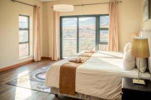 Un dormitorio con una cama grande con una ventana grande. en 910 Highland Gate Golf & Trout Estate, en Dullstroom