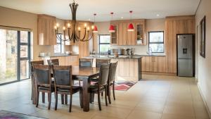 Una cocina con una mesa y sillas de madera. en 910 Highland Gate Golf & Trout Estate, en Dullstroom