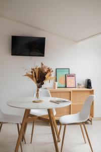 a white dining room with a table and two chairs at Hôtel & Résidence San Roccu in Saint-Florent