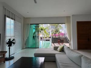 a living room with a couch and a large window at Villa Sa in Ban Saiyuan (1)
