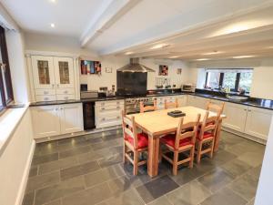 Una gran cocina con una mesa y sillas de madera. en Old Coach House, en Ambleside