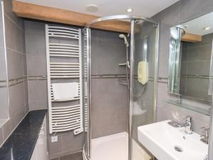 un baño con ducha y lavabo en Old Coach House, en Ambleside 29 fotos más