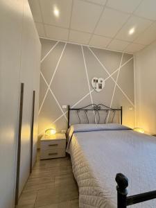 a bedroom with a large bed with a white wall at Cielo Stellato Apartments in Polignano a Mare