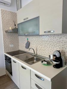 a kitchen with a sink and a counter top at Cielo Stellato Apartments in Polignano a Mare