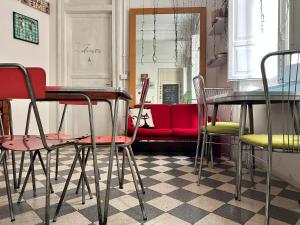 a room with tables and chairs and a red couch at Via Zara Arararooms in Palermo +101 photos