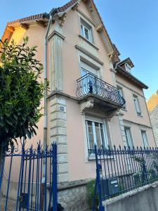 a pink house with a fence in front of it at Jardin de Victor Appartements calmes spacieux avec jardin clos in Belfort