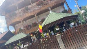 a building with flower boxes and a flag on it at Casa Ionela Petreus in Poienile Izei