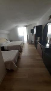 a hotel room with two beds and a desk at Hotel Vila Marco Polo in Slatine