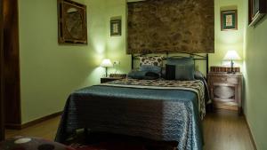 a bedroom with a bed with a blue comforter at Casa El Mirador del Miño en la Ribeira Sacra in Rosende