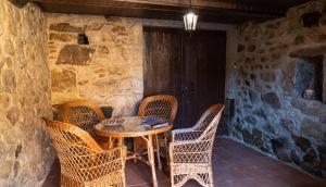 a patio with a table and wicker chairs at Casa El Mirador del Miño en la Ribeira Sacra in Rosende