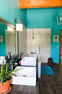 een badkamer met twee witte wastafels en een blauwe muur bij Bergerie rénovée au cœur de la Provence in Plan dʼAups +82 foto's