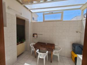 a room with a table and chairs and a window at Dimora Sciroccu e Tramuntana in Taviano