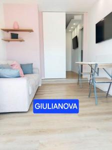uma sala de estar com um sofá branco e uma mesa em Attico con Terrazzo Panoramico e cucina attrezzata, Nel centro di Giulianova, a due passi dal Mare, Con Servizio biciclette em Giulianova