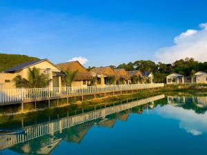une rangée de maisons à côté d'une masse d'eau dans l'établissement Sai Gon Ha Tien Resort, à Hà Tiên