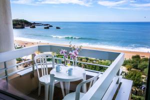 a balcony with a table and chairs and the beach at Résidence Victoria Surf in Biarritz